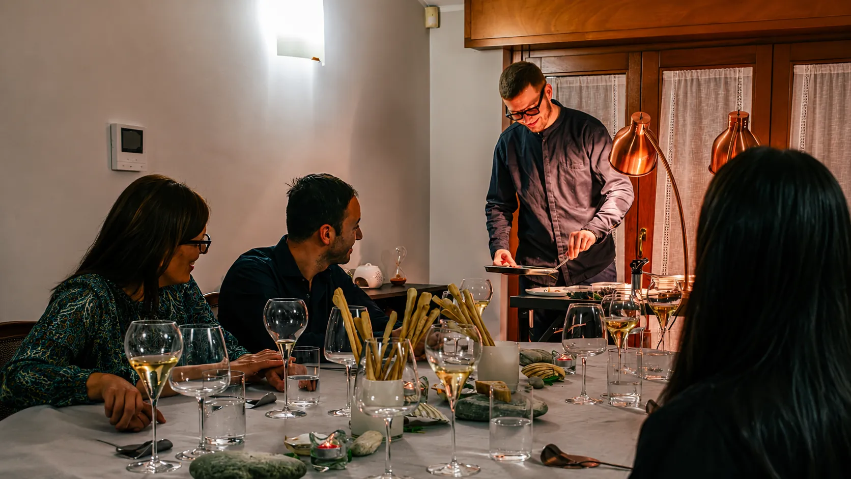 Lo chef serve una cena privata al tavolo degli ospiti